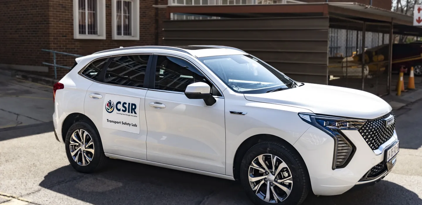 White car with CSIR logo in front of building